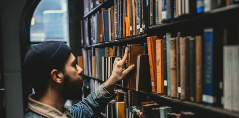 Man picking a book in a library